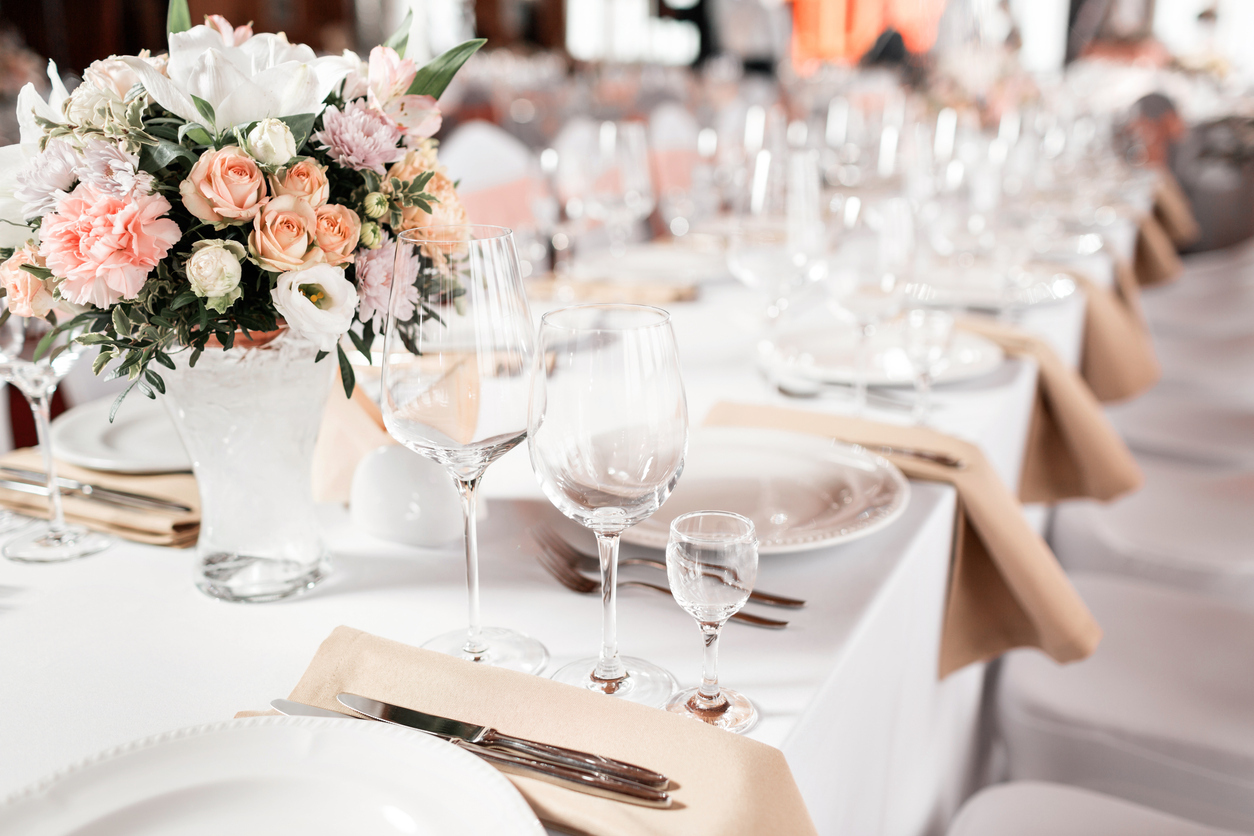 Festlich gedeckter Tisch mit Blumenstrauß und Glasgeschirr