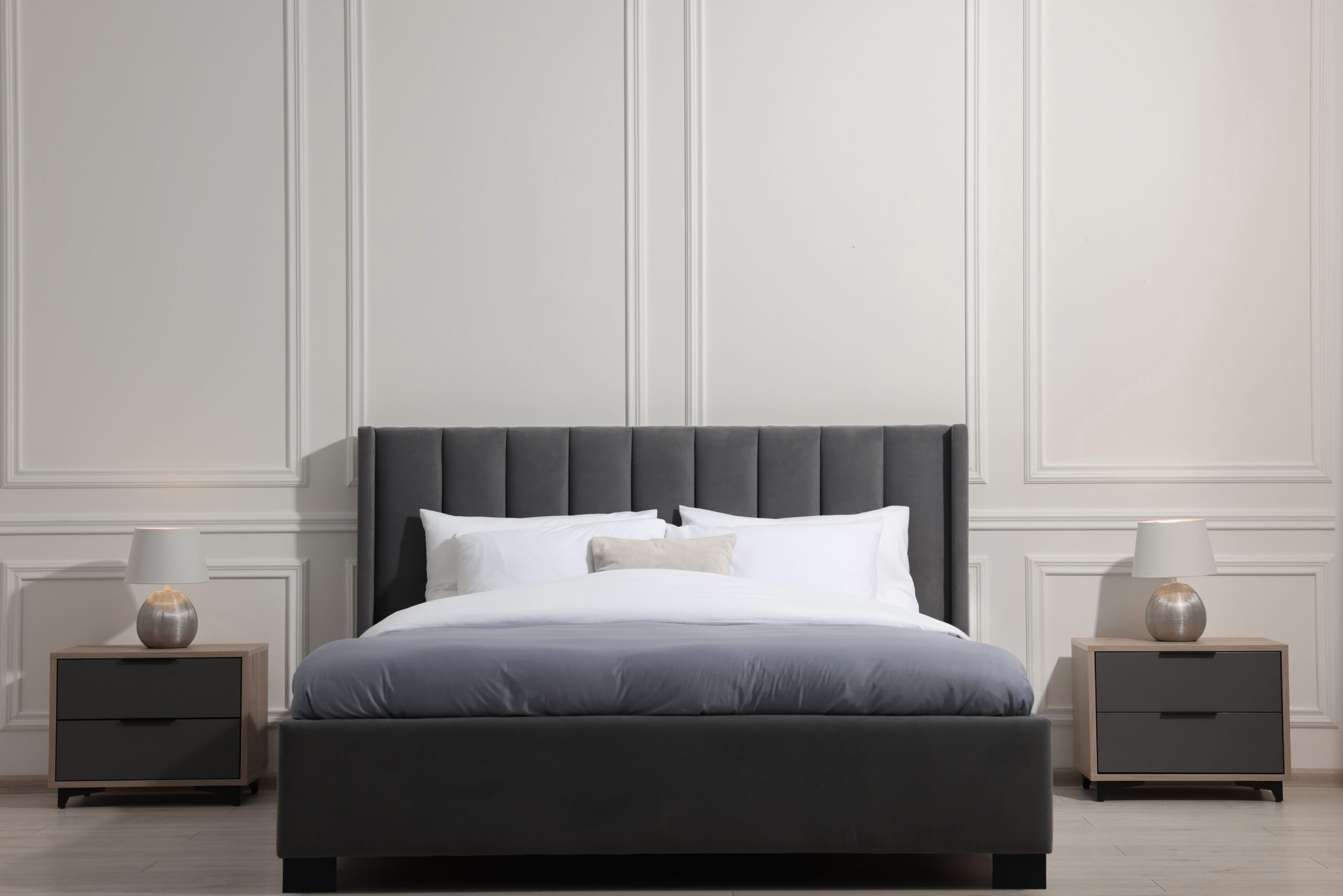 Boxspringbett vor weißem Hintergrund mit zwei Nachttischen