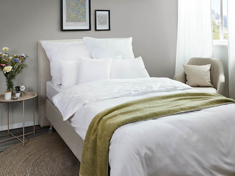 Satin-Bettwäsche Lynn | 140x210, weiß Elegantes weißes Bett mit weicher Satin-Bettwäsche, dekoriert mit grüner Decke.